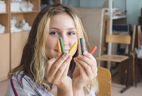girl showing crayons
